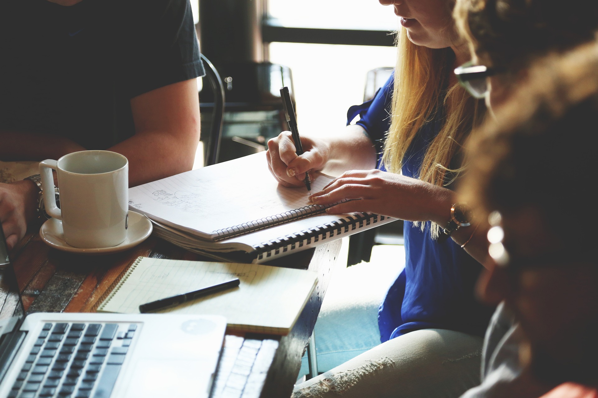 Trends in COBRA Administration Header Image - Team is gathered around laptop coffee and papers